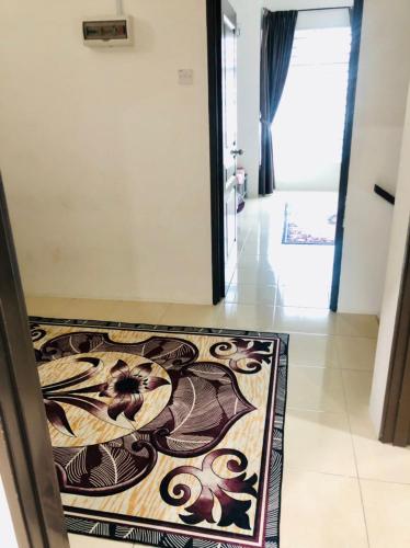 a hallway with a rug on the floor in a house at Homestay Cahaya 1 Seri Iskandar in Seri Iskandar