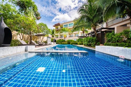 a swimming pool in front of a building at Hotel COCO Phuket Bangtao Beach in Bang Tao Beach