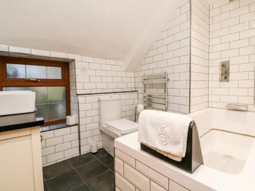 uma casa de banho com uma banheira, um WC e um lavatório. em The Thatched Cottage em Crediton