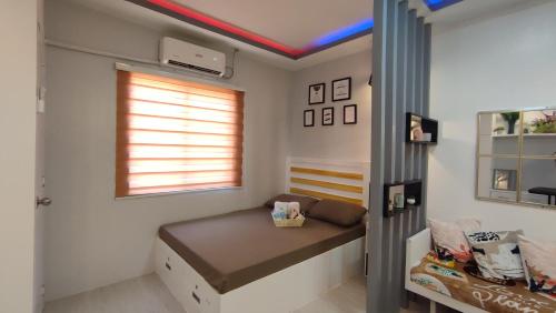 um pequeno quarto com uma cama e uma janela em CG's place (modern condo in cdo) em Cagayan de Oro