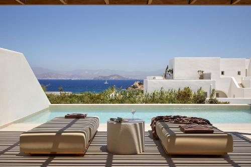 two beds sitting next to a swimming pool at PAROCKS Luxury Hotel & Spa in Ambelas