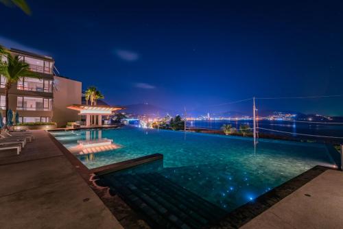 a swimming pool at night with a building at Oceanfront Beach Resort in Patong Beach