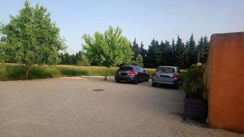 two cars are parked in a parking lot at Gîte Mas de la Restanque in Monteux