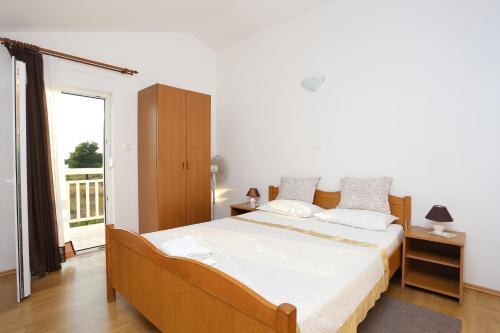 ein Schlafzimmer mit einem großen Bett und einem Balkon in der Unterkunft Apartments by the sea Rogoznica - 4162 in Rogoznica