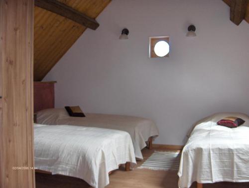 1 dormitorio con 2 camas y una ventana en la pared en Gîte de la Ferme Dufresne en Bernières