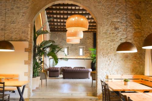 un restaurante con mesas y sillas y un sofá en Masos Can Sot, en Pont de Molins