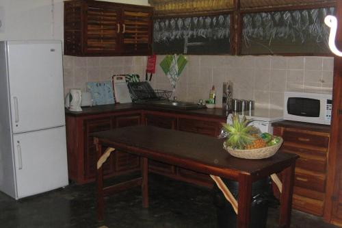 Casa Coco Palmeira في إنهامبان: مطبخ مع طاولة عليها صحن من الفواكه