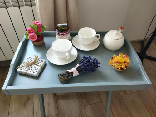 a blue table with tea cups and plates on it at Pokoje goscinne u Olguni in Chyrowa