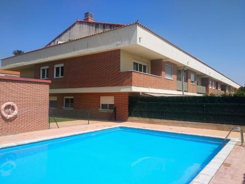 a building with a swimming pool in front of a building at EL JARDIN DE LOS MANANTIALES in Castañares de Rioja