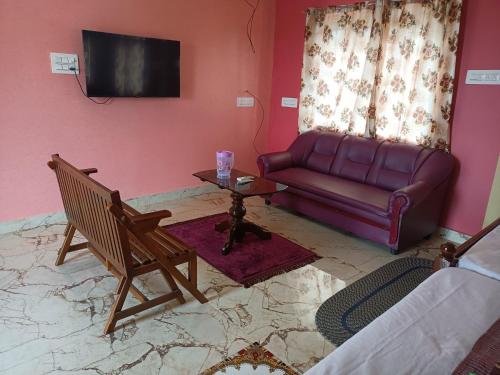 sala de estar con sofá y mesa en Guru Residency Pondicherry, en Pondicherry