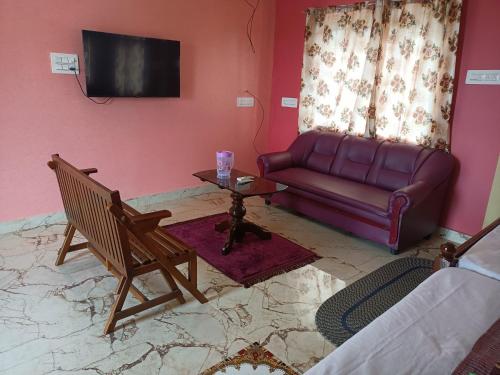 a living room with a couch and a table at Guru Residency Pondicherry in Puducherry