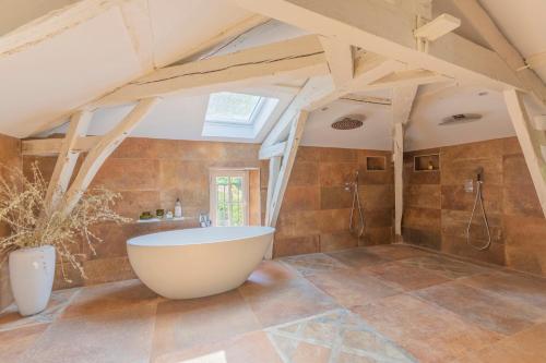 a bathroom with a large tub in the attic at FABULEUX - Domaine du Moulin D'Andraut Bordeaux-Chevaux-Golf-St Emilion in Montussan