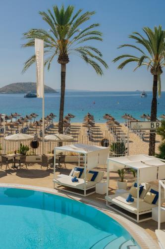 a resort with a pool and a beach with palm trees at Sol House The Studio - Calviá Beach - Adults Only in Magaluf