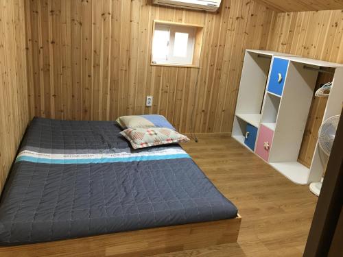 Bongcheon Ville في جيجو: سريرين في غرفة بجدران خشبية