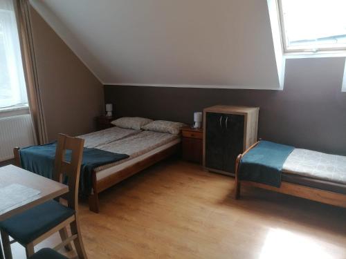 a small room with two beds and a table at Apartamenty Otylka in Wisełka