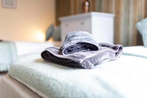a towel is sitting on top of a bed at Russell House, Large townhouse spacious and modern with ground floor bedroom and shower room and free parking in Harraby