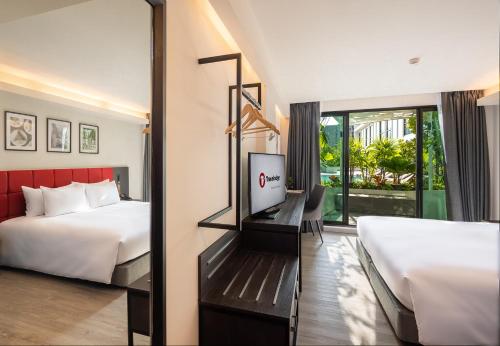 a hotel room with two beds and a mirror at Travelodge Phuket Town in Phuket Town