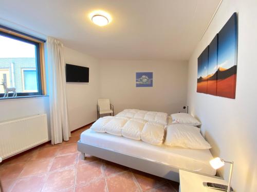 een slaapkamer met een bed en een groot raam bij Callantsoger Staete A304 in Callantsoog