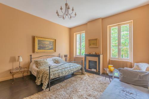 ein Schlafzimmer mit einem Bett und einem Kamin in der Unterkunft FABULEUX - Domaine du Moulin D'Andraut Bordeaux-Chevaux-Golf-St Emilion in Montussan