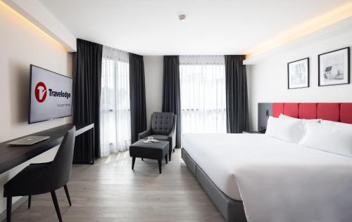 a hotel room with a large bed and a desk at Travelodge Phuket Town in Phuket Town