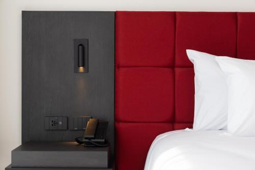 a hotel room with a bed and a phone on a night stand at Travelodge Phuket Town in Phuket Town