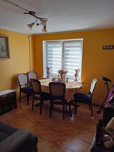 U Ani في Kowal: غرفة طعام مع طاولة وكراسي ونافذة