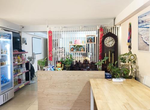 una habitación con un reloj en la pared y una mesa en TrangTien Hostel, en Hanói