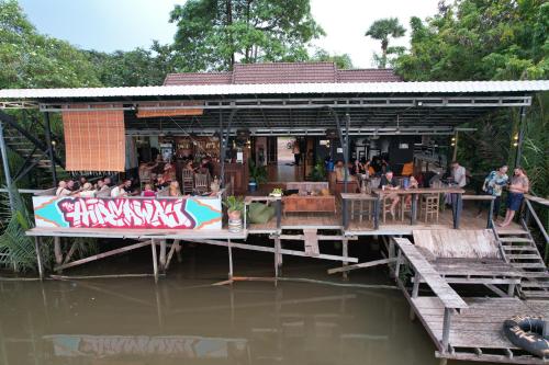 a restaurant on the water with people sitting at tables at The Hideaway in Kampot