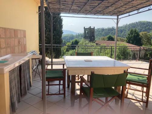 patio con mesa y sillas en el balcón en Villa Valle dei Fiori en Mulazzo