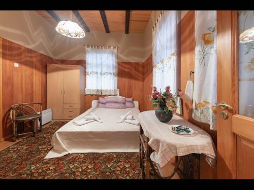 Un dormitorio con una cama y una mesa con flores. en Valensija - Cute cottage in big yard, en Jūrmala
