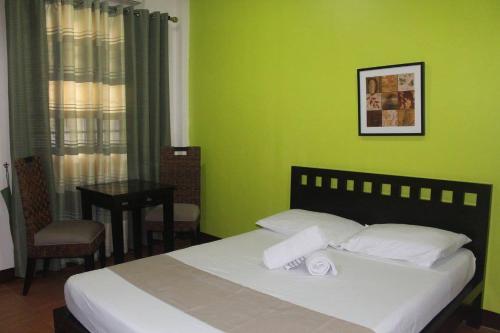 1 dormitorio con paredes verdes y 1 cama con 2 toallas en CASA DEL ROQUE en Ángeles