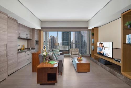 a living room with a couch and a tv at Ascott IFC Guangzhou - Free Shuttle Bus For Canton Fair in Guangzhou