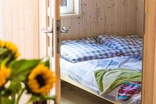 Ce lit superposé se trouve dans un dortoir en bois orné d'une fleur. dans l'établissement Laguna, à Rusinowo