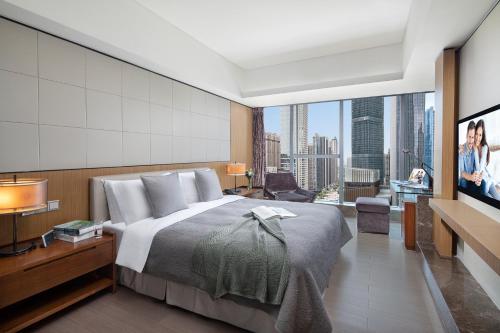 a bedroom with a large bed and a large window at Ascott IFC Guangzhou - Free Shuttle Bus For Canton Fair in Guangzhou