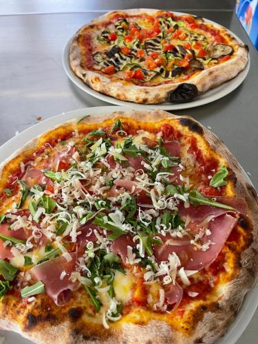 two pizzas sitting on plates on a table at Hotel Restaurant Rothorn in Visperterminen