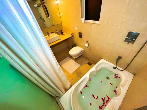 een badkamer met een wastafel, een toilet en een bad bij Hotel Clarks Collection Bhavnagar in Bhavnagar