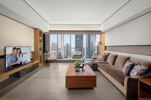 a living room with a couch and a tv at Ascott IFC Guangzhou - Free Shuttle Bus For Canton Fair in Guangzhou