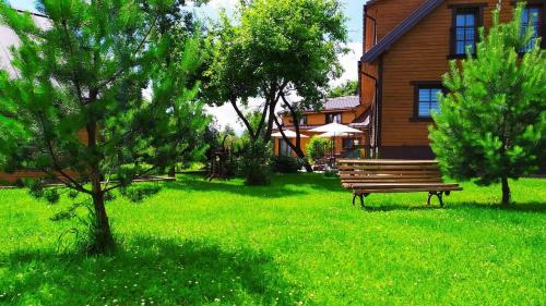 a bench sitting in the grass in front of a house at "Trakaitis" apartments & holiday homes in Trakai