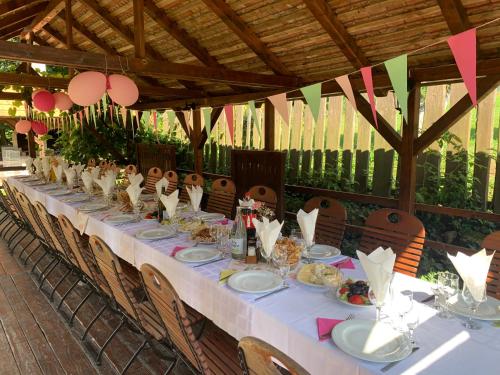 a long table with plates of food on it at Csíki Határ Fogadó/ Hanul Hotarul Ciucului in Bixad