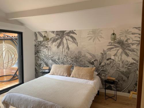 a bedroom with a wall mural of palm trees at Cap Ferret - Villa Sérénité - piscine, proche Océan et Bassin, classée 4 étoiles Meublé de tourisme in Lège-Cap-Ferret