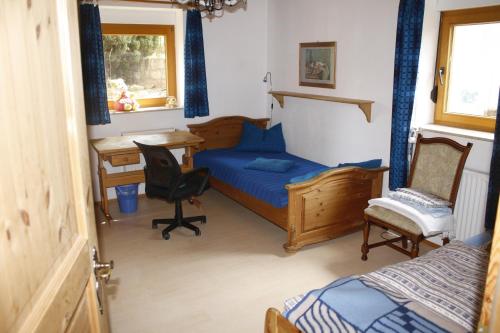 a bedroom with a bed and a desk and a chair at Ferienwohnung Weilerbach in Weilerbach
