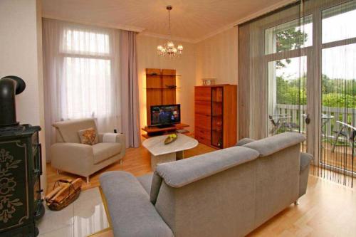 a living room with a couch and a table and a tv at SW6 Haus Wittsand in Spieka-Neufeld