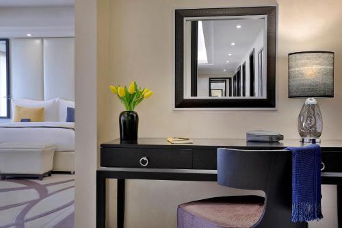 a bedroom with a desk with a mirror and a bed at Voco - Riyadh by IHG in Riyadh