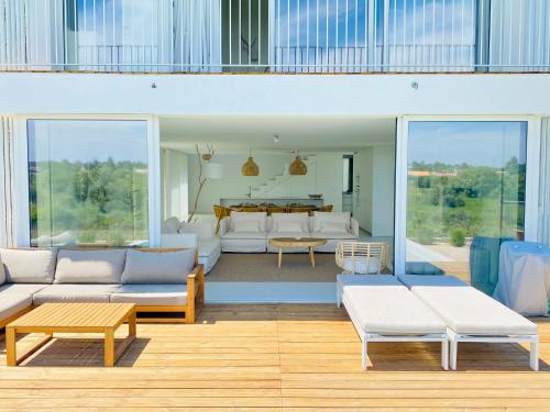 uma sala de estar com mobiliário branco e uma mesa em Villa Possanco, Comporta beach villa na Comporta