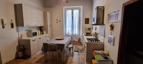 a small kitchen with a table and a stove at Onda Blu - Bilocale con Aria Condizionata a due passi dal Castello e dal Torrione e Rivellino in Piombino