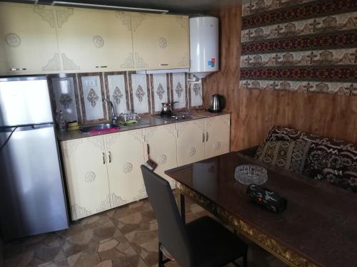 a kitchen with a table and a refrigerator at Golden Beach Sevan in Tsovazard