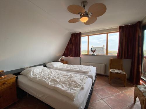 a bedroom with two beds and a ceiling fan at Callantsoger Staete A305 in Callantsoog