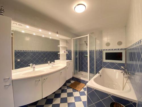 a blue and white bathroom with a tub and a sink at Callantsoger Staete A305 in Callantsoog