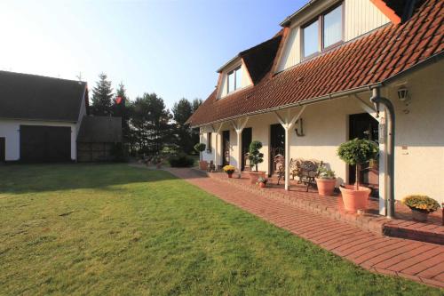 a house with a brick walkway next to a yard at Ruegen_Fewo 155 in Veikvitz