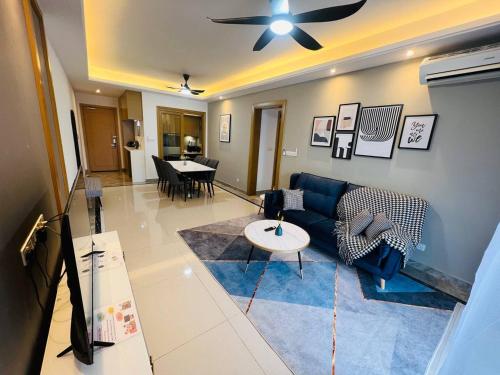a living room with a blue couch and a ceiling fan at R&F PRINCESS COVE at ANJU in Johor Bahru